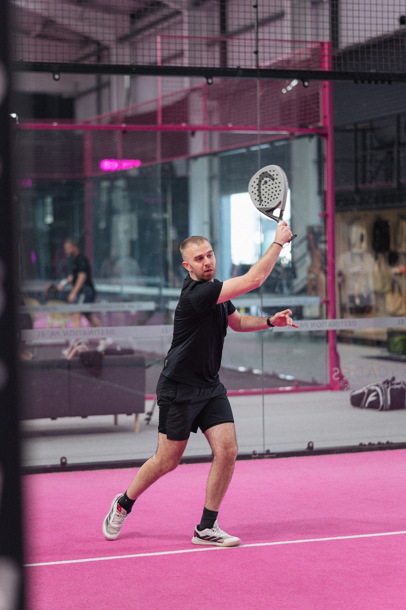 Padel player swinging on a pink court