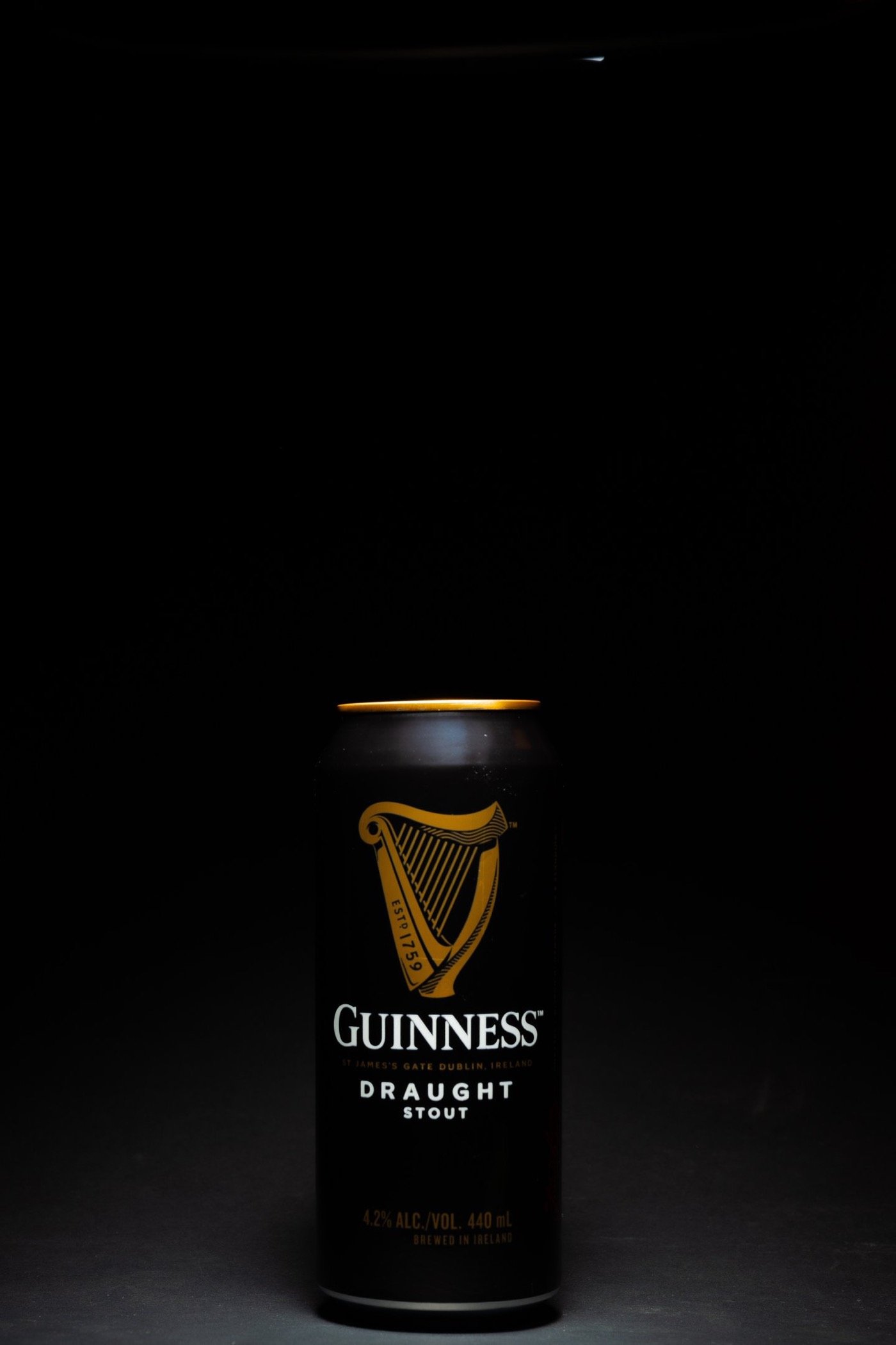 Guinness Draught can lit on a black background