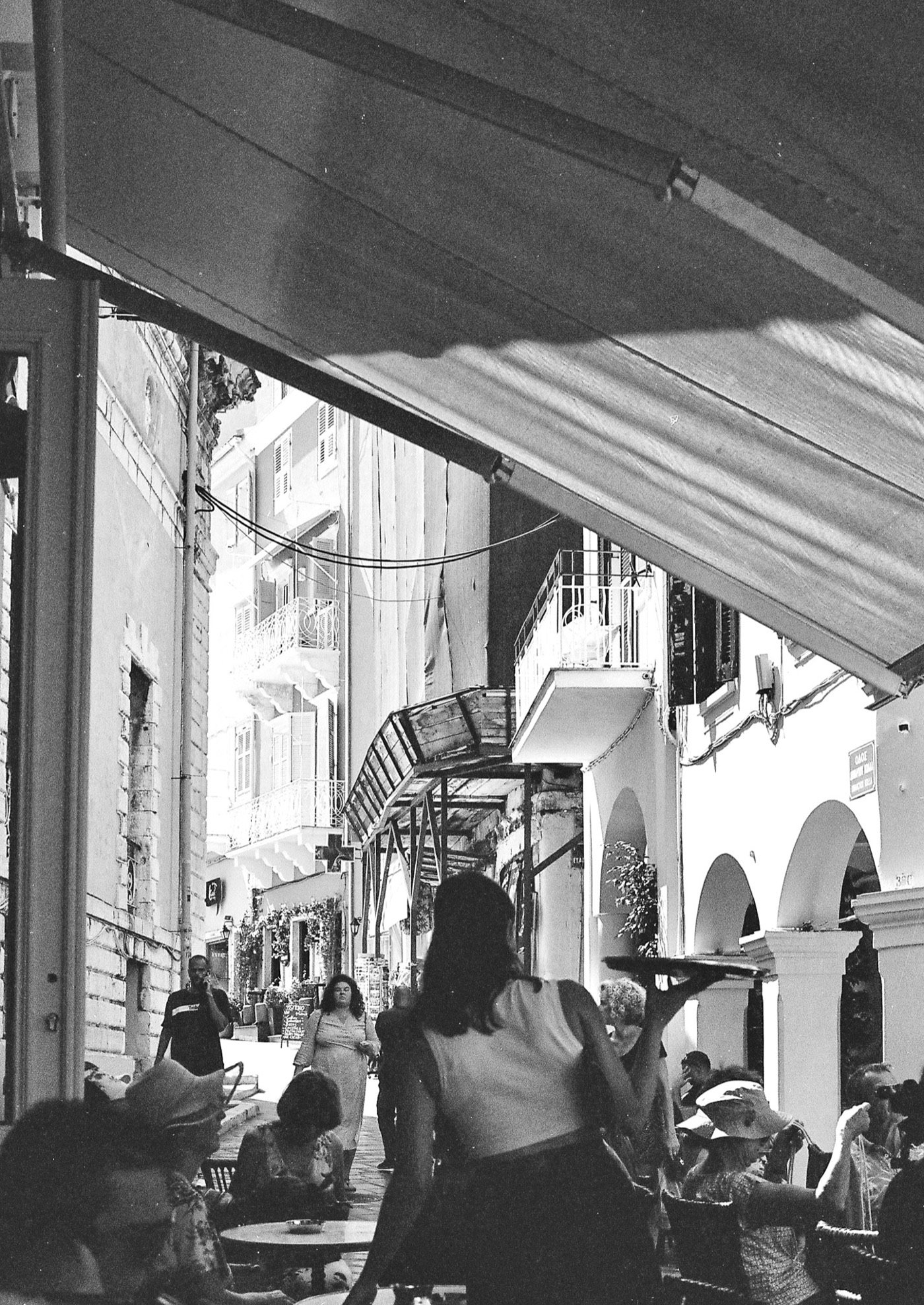 Black-and-white street scene through an archway