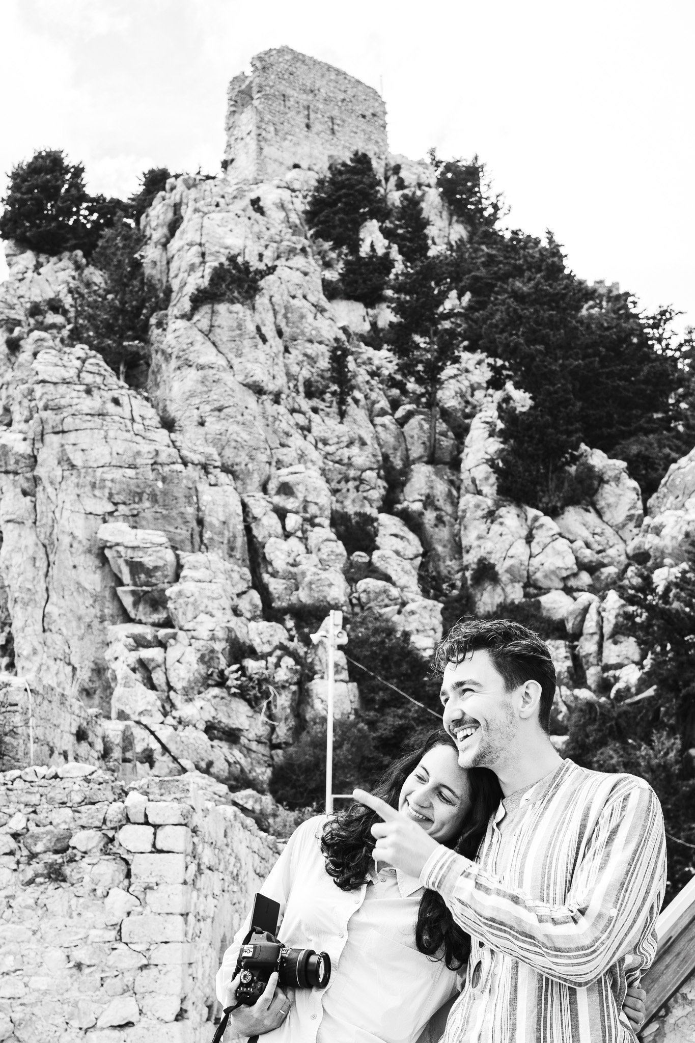 Black-and-white photo of a couple below castle ruins