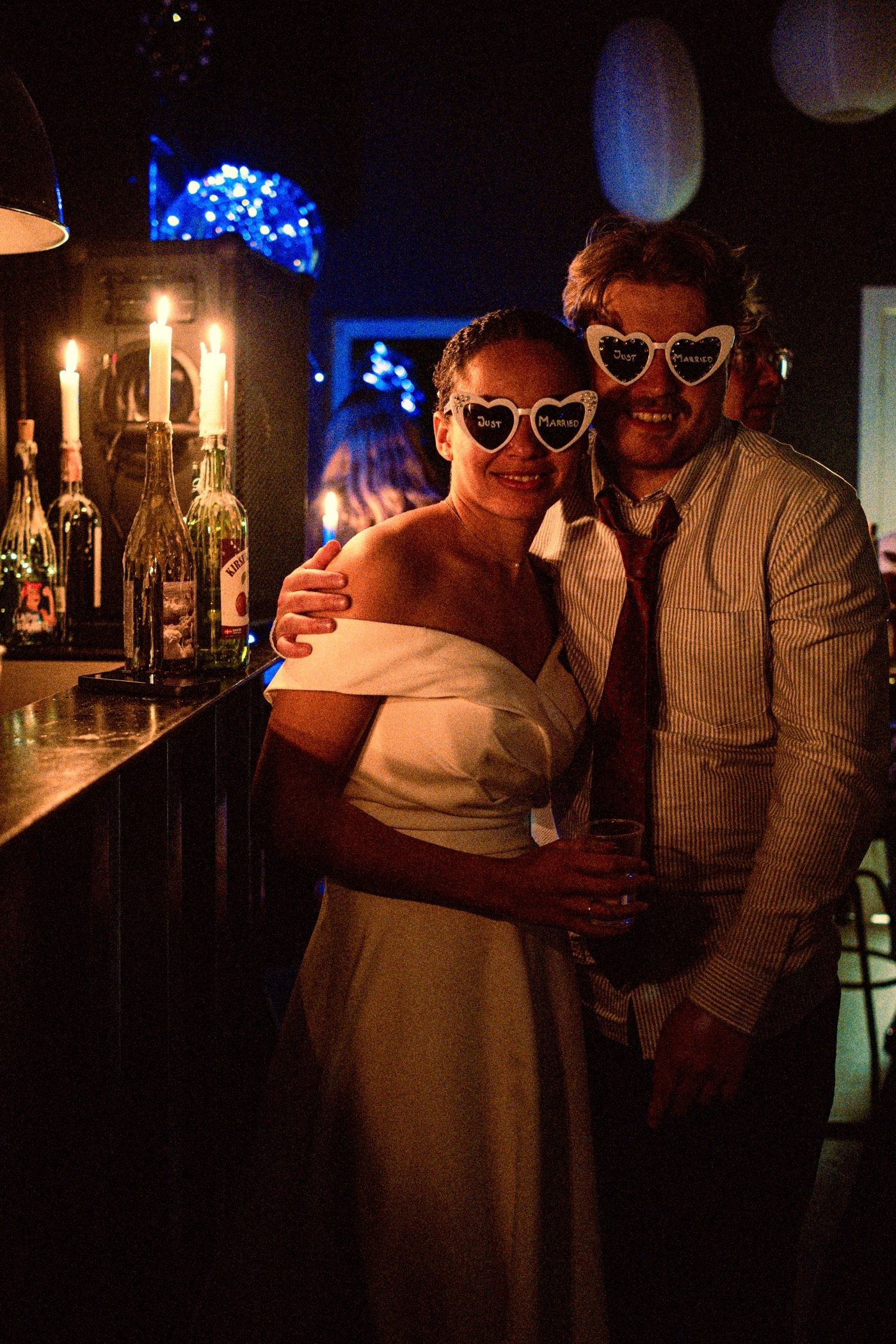 Couple in heart-shaped sunglasses at a candlelit party