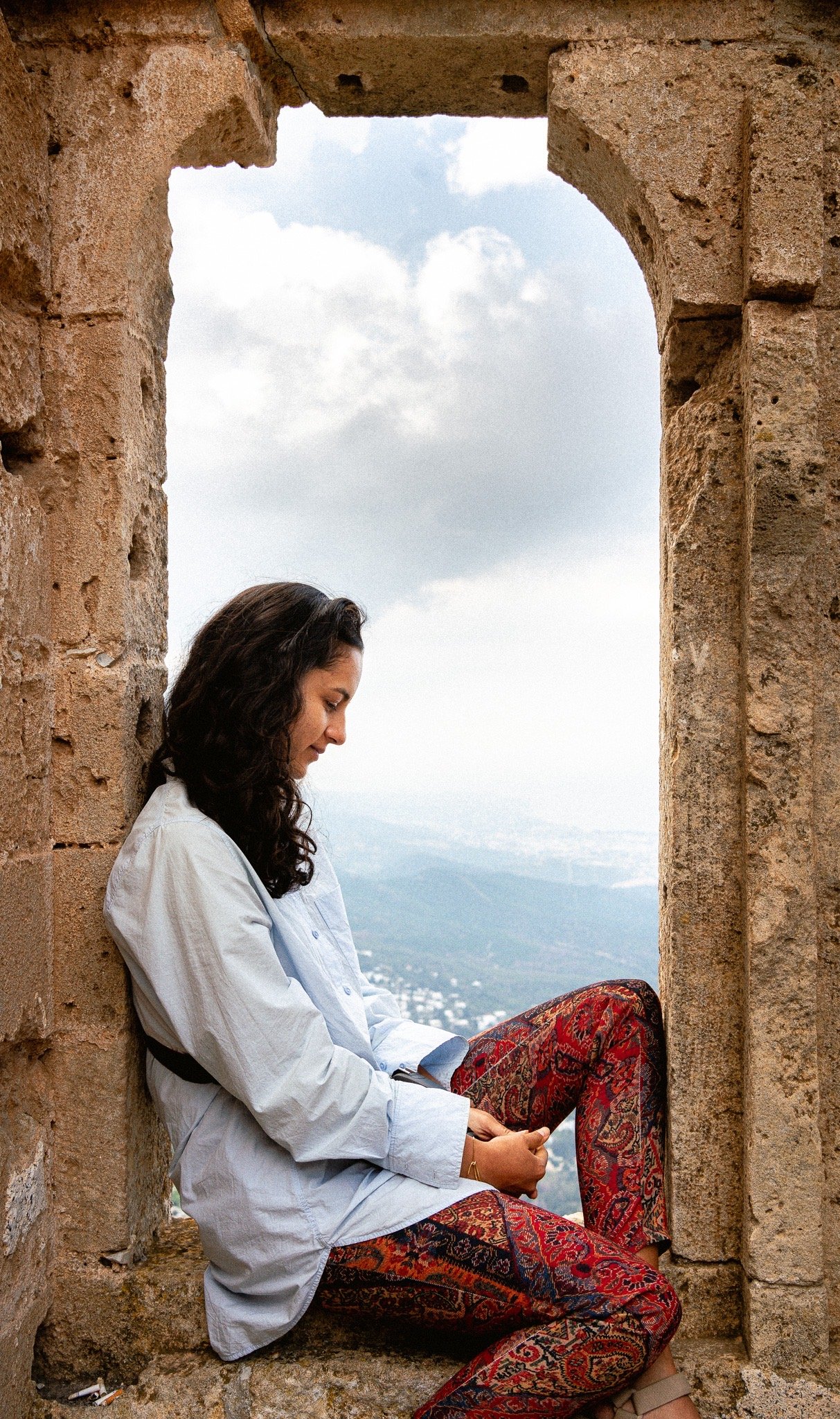 Woman sitting in a stone window