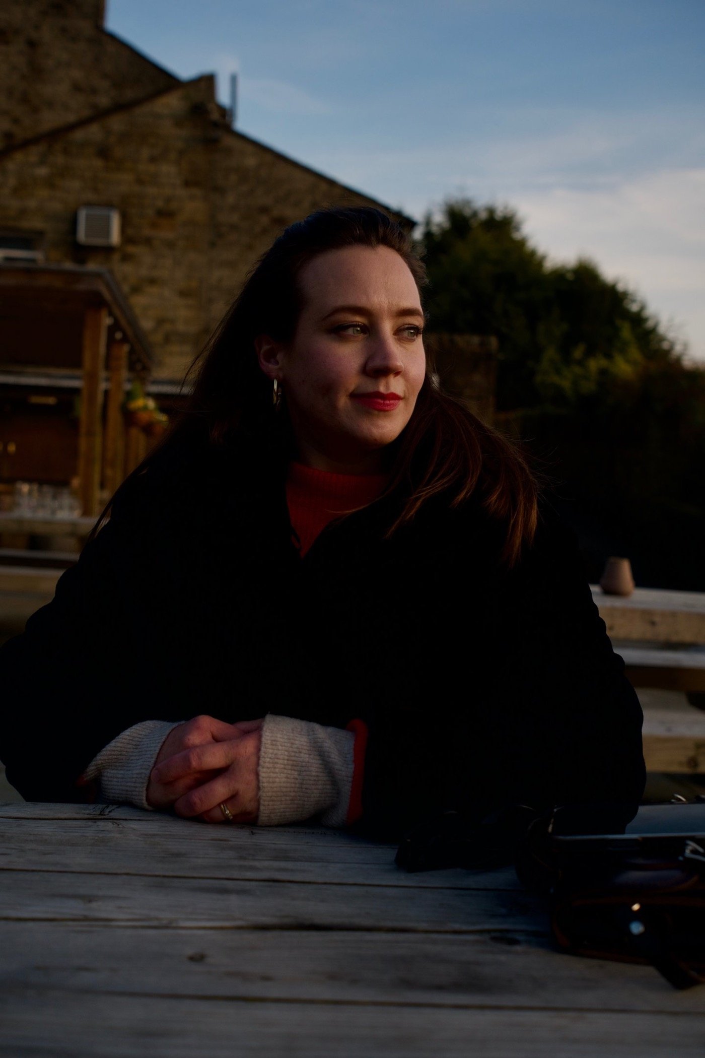 Woman seated outdoors at dusk