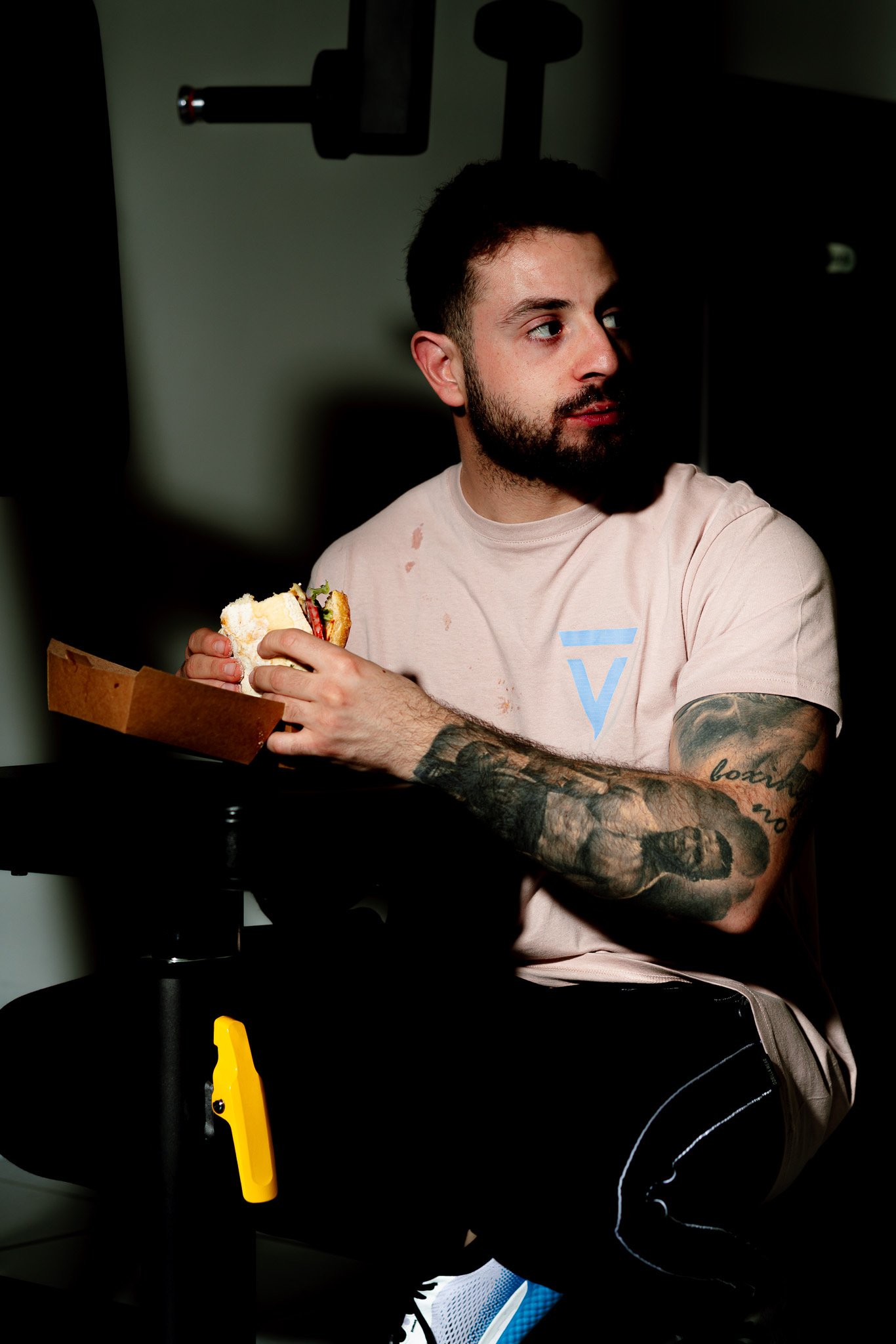 Bearded man with tattooed arms in dramatic light