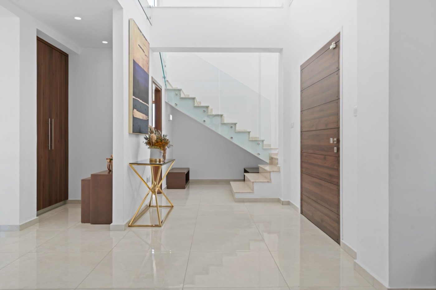 White hallway with a glass staircase
